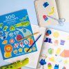 Tento barevný sešit z kolekce Les Toupitis je určený pro nejmenší děti od 2 let. Obsahuje 300 samolepek přehledně rozdělených podle barev. Samolepky jsou snadno odnímatelné a znovupoužitelné, takže si s nimi poradí i malé ručičky. Skvělá aktivita na doma i na cesty.  Proč si ho děti zamilují? • 300 samolepek k neomezenému tvoření • snadno odlepitelné a znovu použitelné • přehledné uspořádání podle barev • ideální velikost pro malé dětské ruce • praktický sešit, který lze vzít kamkoli  Podporuje u dětí • jemnou motoriku při odlepování a lepení • poznávání barev a třídění podle kategorií • kreativitu a vlastní vyjadřování • radost ze samostatného tvoření  Obsah balení a parametry • 1 sešit se 300 samolepkami • kolekce: Les Toupitis • materiál: papír, plast • věk: od 2 let • rozměry produktu: 26 × 1 × 32 cm  Názor logopedky Mgr. Daniely Pravcové Samolepky jsou výborným prostředkem pro rozvoj řeči i jemné motoriky. Děti mohou pojmenovávat barvy („to je červená“), hledat a třídit samolepky podle zadání („najdi všechny modré“) a tvořit jednoduché věty („kočka je zelená“). Rodič může podpořit hru otázkami: „Kam tu samolepku nalepíš? Co je na obrázku?“ – tím se rozvíjí slovní zásoba, větná stavba i schopnost popisu.